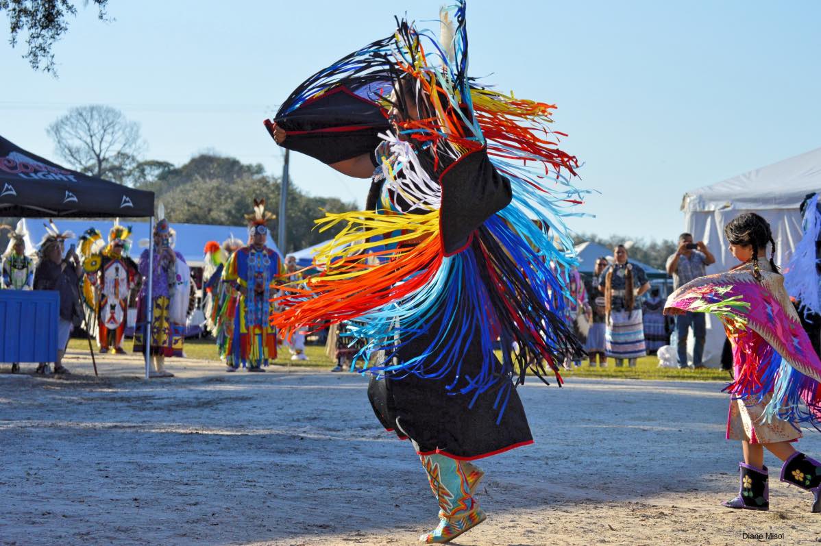 Native American dancing followed by child