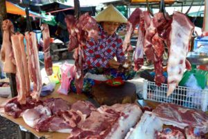 Meat Vendor Sits on her Stand Eating an Egg - Phu Quoc, Vietnam