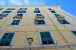 Yellow Wall of Windows with Green Shutters - Civitavecchia, Italy